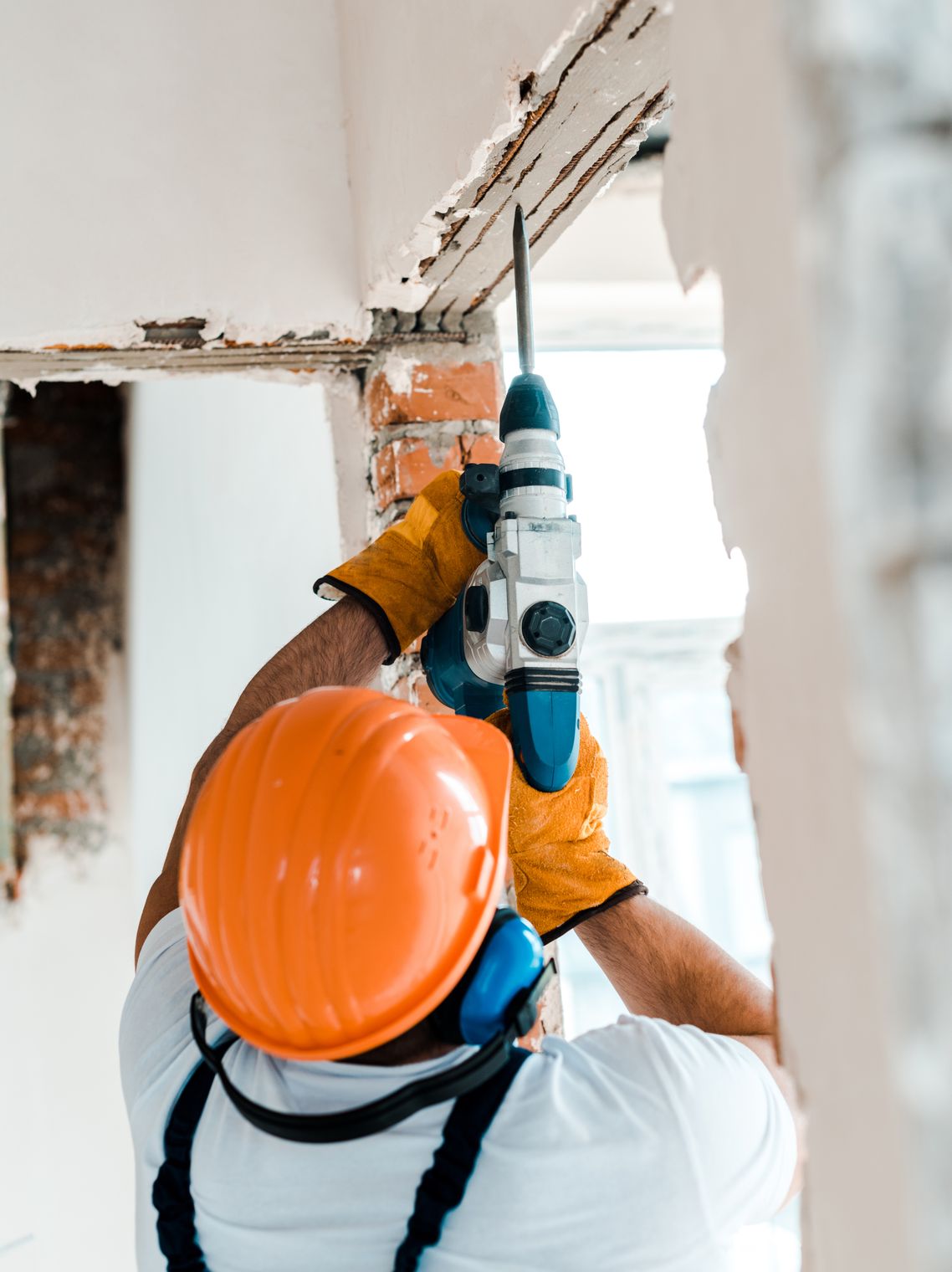 Construction worker drilling a hole in the ceiling